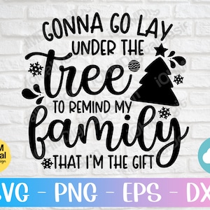 May include: Black and white graphic design with the text "Gonna go lay under the tree to remind my family that I'm the gift". The design features a stylized Christmas tree with snowflakes and ornaments.