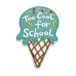 May include: An embroidered patch shaped like an ice cream cone with a teal scoop featuring white text that reads Too Cool for School, accented by small yellow lightning bolts and colorful sprinkles, atop a brown and white waffle cone pattern.