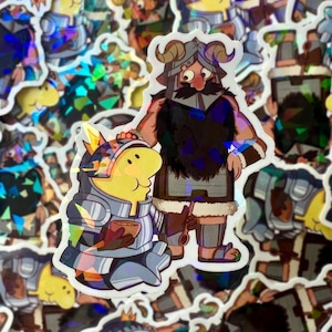 May include: Holographic stickers featuring cartoon characters in knight and barbarian attire. The knight is yellow and the barbarian has a large mustache and beard. The stickers have a shiny, iridescent finish.