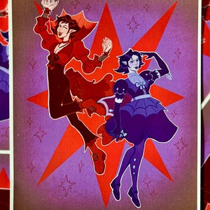 May include: Illustration of two figures in stylized outfits, set against a red starburst on a purple background. One figure is in red, the other in purple. The artwork has a whimsical, fantasy theme.