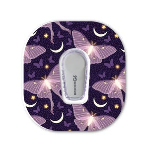 May include: A Dexcom G6 continuous glucose monitor transmitter centered on an oval adhesive patch featuring a dark purple background with a repeating pattern of light purple moths, small yellow stars, and white crescent moons.