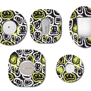 May include: Five different designs of round and oval shaped stickers with a black background and yellow smiley faces. The stickers are designed to cover medical devices.