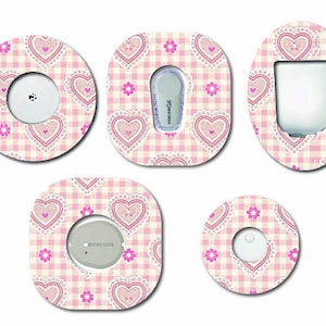 May include: Five adhesive patches for medical devices featuring a light pink and white gingham pattern with decorative hearts and small pink flowers. The patches are shaped to fit around various glucose monitors and insulin pump components.