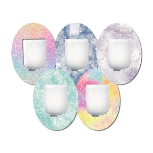 May include: A collection of five oval-shaped decorative stickers with a white, rectangular object in the center. Each sticker features a unique watercolor-style background with glitter accents in shades of pink, blue, purple, and yellow.
