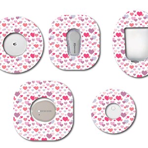 Peut inclure: Cinq designs différents de patchs adhésifs pour un appareil médical. Chaque patch présente un fond blanc avec un motif de cœurs roses et violets. Les patchs sont conçus pour recouvrir l'appareil et ajouter une touche personnelle.