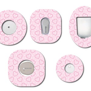 May include: Five pink and white patterned adhesive covers for a medical device. The covers feature a repeating pattern of small white dots and pink hearts. The covers are designed to fit different shapes and sizes of medical devices.