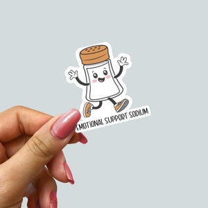 May include: A white salt shaker with a smiling face and orange shoes runs with the text "Emotional Support Sodium".