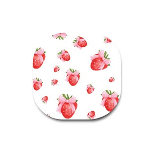 May include: A white square-shaped object with rounded corners featuring a repeating pattern of red strawberries. Each strawberry is illustrated with a small light pink bow tied around its green stem, creating a consistent decorative motif across the surface.