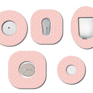 May include: Five insulin pump site covers in pink and white polka dot design. The covers are in various shapes and sizes, including round, oval, and square. Each cover has a central hole for the insulin pump.