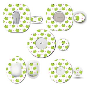 Peut inclure: Plusieurs patchs adhésifs pour dispositifs médicaux avec un motif répété de visages de grenouilles vertes et de petits cœurs roses sur fond blanc. Les patchs sont de formes et de tailles variées, rondes, ovales et rectangulaires.