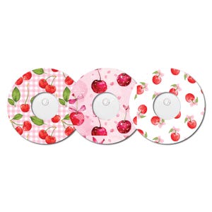 May include: Three round, pink and white patterned stickers with a cherry design. Each sticker has a hole in the centre.