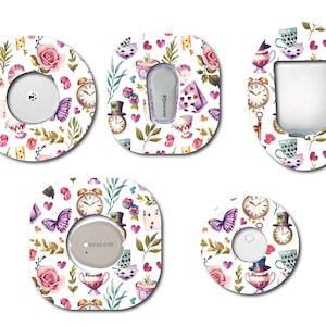 Peut inclure: Cinq designs différents pour un couvre-dispositif médical de forme ronde, carrée et ovale. Les motifs présentent un thème de fête du thé fantaisiste avec des tasses à thé, des horloges, des cartes à jouer, des papillons et des roses. Les motifs sont dans des tons de rose, violet, vert et bleu sur un fond blanc.