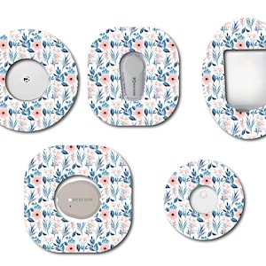 May include: Five different designs of adhesive stickers for a medical device. The stickers feature a white background with a repeating pattern of pink flowers and blue leaves. The stickers are designed to cover the device and add a decorative touch.