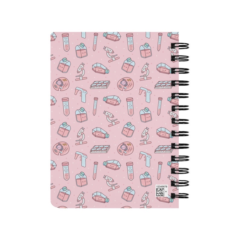 Peut inclure: Un carnet rose avec une reliure spirale. La couverture pr&eacute;sente un motif r&eacute;p&eacute;t&eacute; d'illustrations sur le th&egrave;me des sciences, notamment des b&eacute;chers, des tubes &agrave; essai, des microscopes et des bo&icirc;tes de P&eacute;tri.