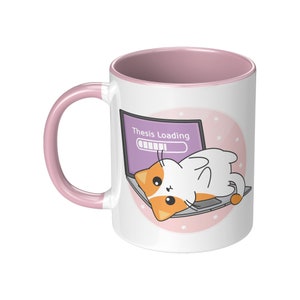 Pode incluir: Caneca de cerâmica branca com borda e alça rosa. A caneca apresenta uma ilustração de desenho animado de um gato branco com orelhas laranja deitado em um laptop com o texto "Thesis Loading" e uma barra de progresso na tela. O fundo é rosa com estrelas brancas.
