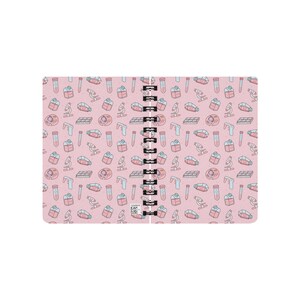 Peut inclure: Un carnet &agrave; spirales rose avec un motif sur le th&egrave;me des sciences. Le motif comprend des tubes &agrave; essai, des microscopes, des bo&icirc;tes de P&eacute;tri et des cellules.