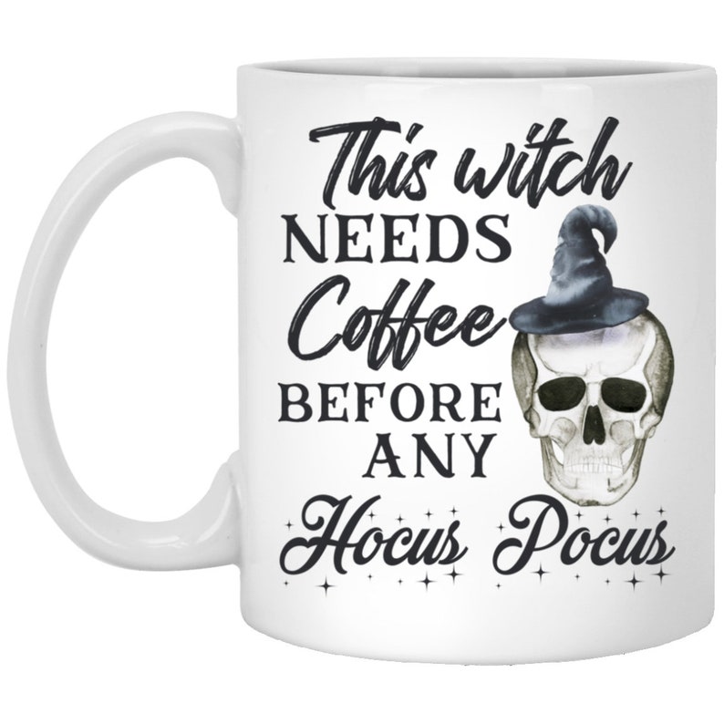 May include: White ceramic coffee mug with the text "This witch NEEDS Coffee BEFORE ANY Hocus Pocus" in black script. A skull wearing a witch hat is on the right side of the mug. The mug has a white handle.