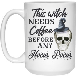 May include: White ceramic coffee mug with a black handle. The mug features the text "This witch NEEDS Coffee BEFORE ANY Hocus Pocus" in a whimsical font, along with a skull wearing a witch hat.