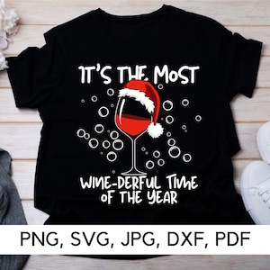 May include: Black t-shirt with a white graphic of a wine glass with a Santa hat on top. The text "It's the most Wine-derful Time of the Year" is below the glass.