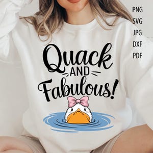 May include: White sweatshirt featuring the phrase "Quack AND Fabulous!" in black script, with a cartoon duck wearing a pink bow. The image also includes file type options: PNG, SVG, JPG, DXF, and PDF.