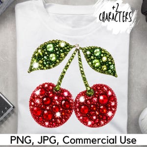 Puede incluir: Una camiseta blanca con un gráfico de dos cerezas hechas de pedrería roja y verde facetada. El diseño incluye dos frutos circulares rojos con tallos verdes y dos hojas verdes, todo ello representado con una textura brillante y cristalina.
