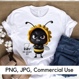 May include: White t-shirt with a cartoon image of a grumpy bee wearing a yellow flower. The bee has black eyes, a black body, and yellow and black stripes. The text "Ruby the Grumpy Bee!" is printed below the bee.
