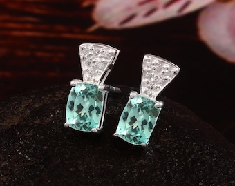 Peut inclure: Une paire de boucles d'oreilles en argent avec une pierre précieuse bleu clair et un accent de cristal transparent.