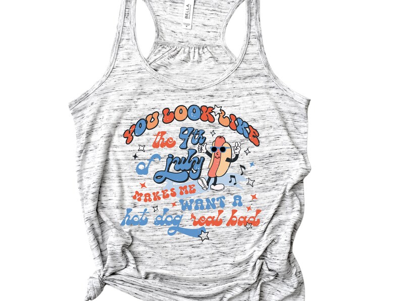 May include: A gray tank top with a white and gray speckled pattern. The text "You look like the 4th of July" is printed in red, orange, and blue. A cartoon hot dog with sunglasses is dancing and the text "Makes me want a hot dog real bad" is printed in red, orange, and blue.