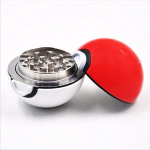 May include: A silver and red metal grinder shaped like a Pokeball. The top half of the grinder is red and the bottom half is silver. The grinder has a metal grinding mechanism.