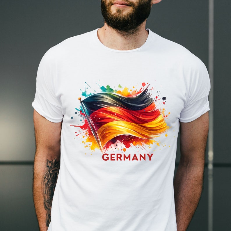 Puede incluir: Camiseta blanca con un dise&ntilde;o de acuarela colorido de la bandera alemana y la palabra "ALEMANIA" impresa debajo.