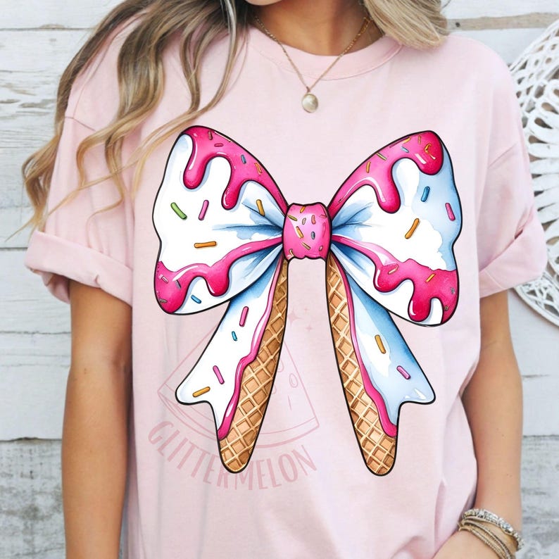 K&ouml;nnte beinhalten: Ein pinkfarbenes T-Shirt mit einem gro&szlig;en Motiv eines wei&szlig;en und blauen Bogens aus Eiswaffeln mit rosa und wei&szlig;en Streuseln. Der Text "Glitter Melon" ist auf der Unterseite des Shirts gedruckt.