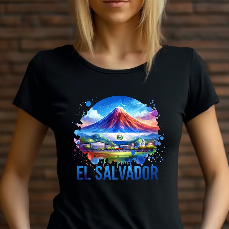 May include: Black t-shirt featuring a colorful watercolor design of El Salvador. The design includes a mountain, the Salvadoran flag, and the text "EL SALVADOR" in blue. The shirt is a crew neck.