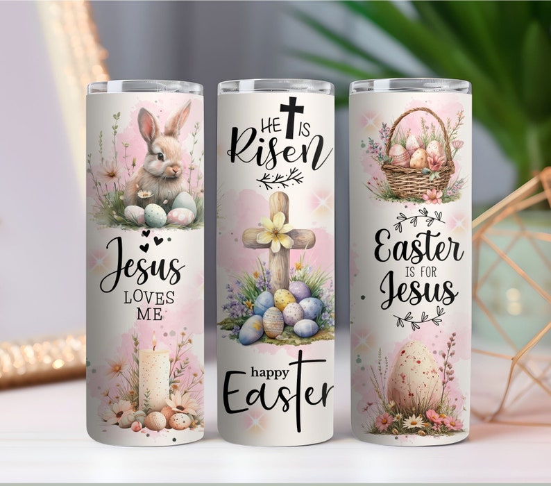May include: Three white stainless steel tumblers with Easter-themed designs. One features a bunny and the text "Jesus Loves Me." Another has a cross and the words "He is Risen" and "Happy Easter." The third shows a basket of eggs and the text "Easter is for Jesus."