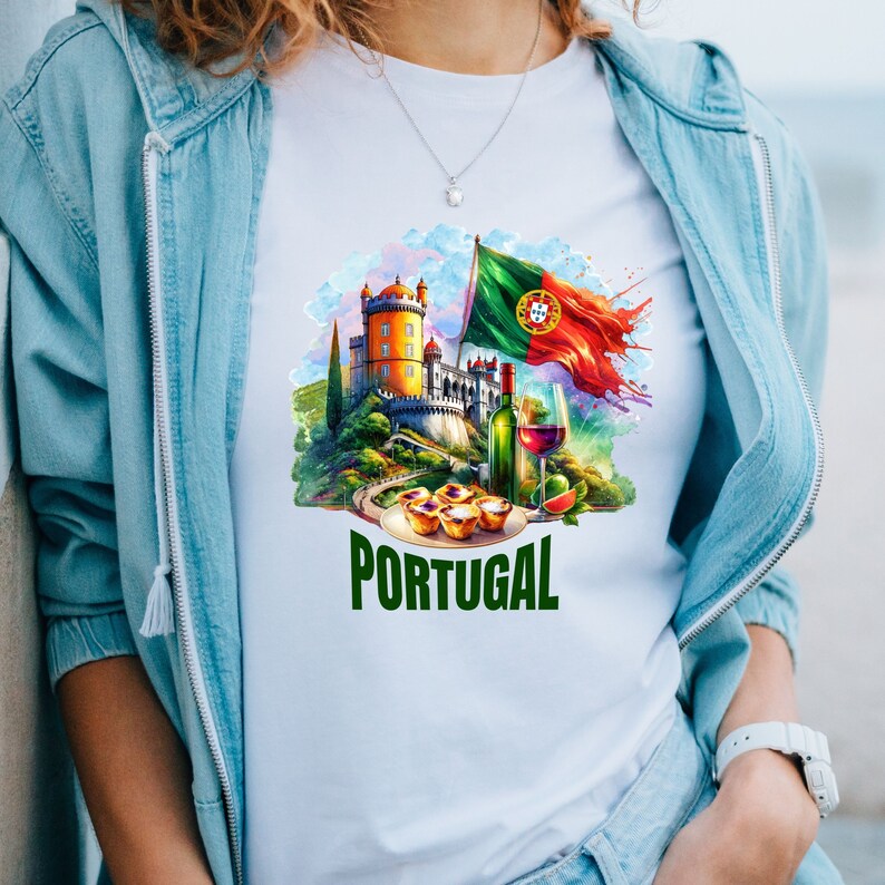 Puede incluir: Camiseta blanca con una ilustraci&oacute;n colorida de un castillo portugu&eacute;s, una bandera, vino y pasteles. El texto "PORTUGAL" est&aacute; impreso en verde debajo de la ilustraci&oacute;n.