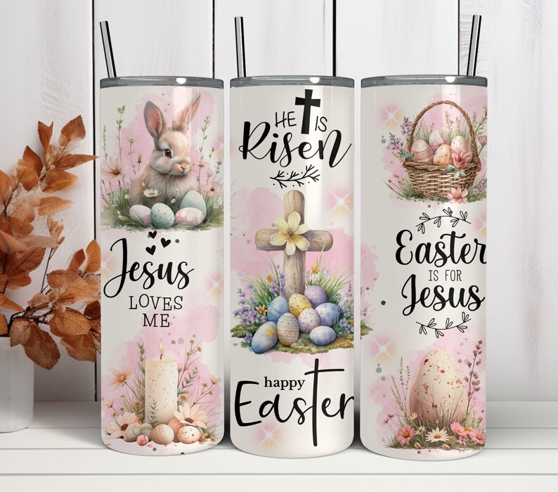 May include: A set of three stainless steel insulated tumblers with black straws. Each tumbler features an Easter-themed design with a bunny, cross, and Easter eggs. The text includes "Jesus Loves Me", "He is Risen", and "Easter is for Jesus".