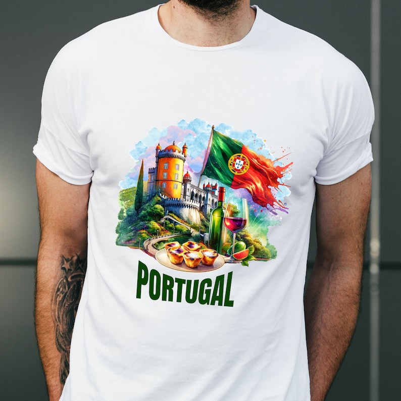 Puede incluir: Camiseta blanca con una ilustraci&oacute;n colorida de un castillo portugu&eacute;s, una bandera, vino y pasteles. El texto "PORTUGAL" est&aacute; impreso en verde debajo de la ilustraci&oacute;n.