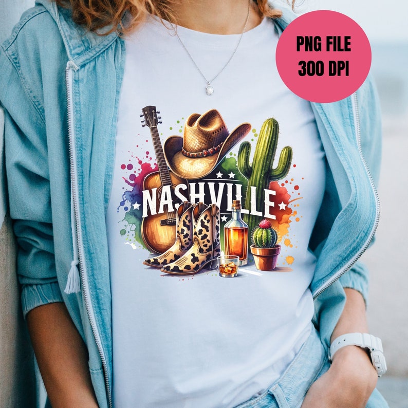 Pu&ograve; includere: Una maglietta bianca con un design colorato che presenta un cappello da cowboy, stivali, una chitarra, cactus e la parola "Nashville".