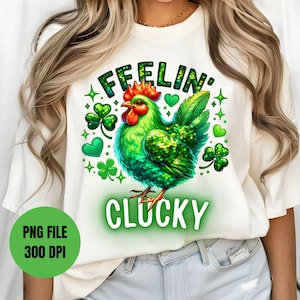 May include: White t-shirt with a green, sparkly chicken and shamrocks. The text "Feelin' Clucky" is written in green.