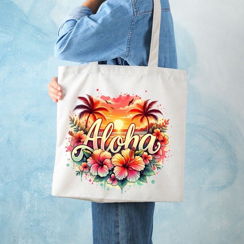 May include: A white tote bag with a colorful design featuring palm trees, a sunset, and the word "Aloha" in a stylized font. The design is surrounded by pink, orange, and yellow hibiscus flowers.