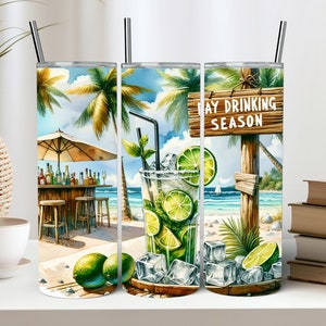 May include: Three stainless steel tumblers featuring a beach scene design. The tumblers depict a tropical beach with palm trees, an umbrella, a bar, and a glass of mojito. The middle tumbler has the text "May Drinking Season" on a wooden sign.