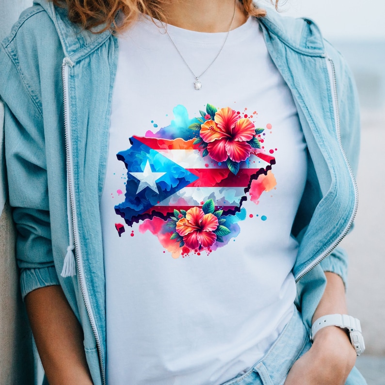May include: A white t-shirt with a watercolor design of the Puerto Rican flag and flowers. The flag is in the shape of the island of Puerto Rico.