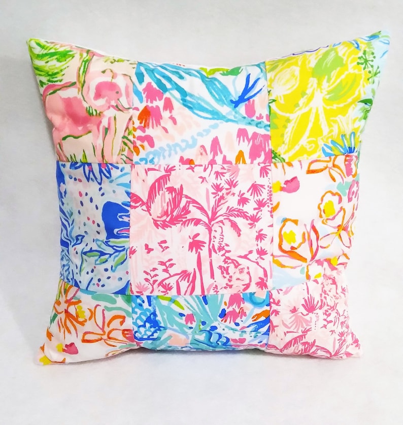 Puede incluir: Una funda de coj&iacute;n de patchwork con fondo blanco y coloridos patrones florales y tropicales. La funda de coj&iacute;n est&aacute; hecha de diferentes telas cosidas juntas en un patr&oacute;n de cuadr&iacute;cula.