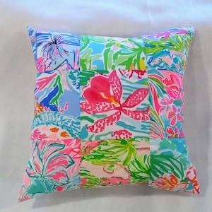 Puede incluir: Una almohada de patchwork con un dise&ntilde;o floral en tonos de rosa, azul y verde. La almohada est&aacute; hecha de diferentes telas con varios patrones florales.