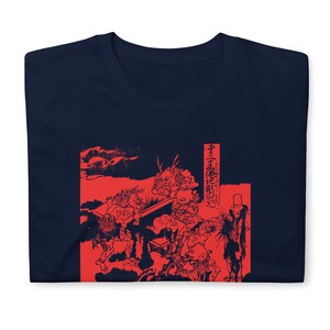 May include: A navy blue t-shirt with a red print of a Japanese woodblock print depicting a scene with multiple figures. The print is in a traditional style and features a red background with black outlines. The text on the right side of the print reads "The Tale of the Great Fire of the Capital".