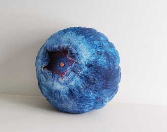 May include: A blue blueberry-shaped pillow with a red center and a textured surface.