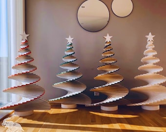 May include: Four wooden spiral Christmas trees in different colors, including red, green, brown, and white. The trees are standing on a wooden floor.