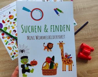 Op de afbeelding: Een kleurrijk boek met de titel "SUCHEN & FINDEN MINI WIMMELBILDERPAKET" op de omslag. Het boek bevat illustraties van een spin, een pompoen, een monster, een leeuw, een giraffe en een mand met fruit.