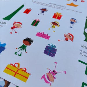 Op de afbeelding: Een kleurrijk activiteitenblad met elfjes en cadeautjes. De tekst op het blad luidt "NACH FARBEN ZUORDNEN" en "UGELS".