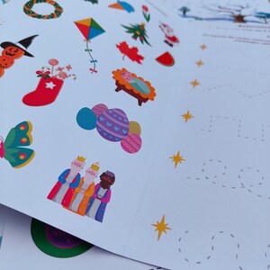 Op de afbeelding: Een set kleurrijke stickers met kerst- en feestthema's, waaronder een krans, een sok, een ster, een kerststal en de drie koningen. De stickers zijn op een witte achtergrond.