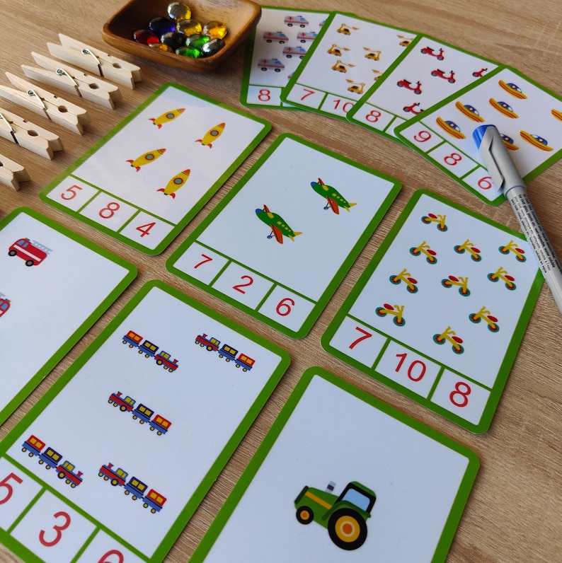 May include: A set of 10 colorful flash cards with various images of vehicles and numbers. The cards are designed to help children learn to count and identify different types of vehicles.